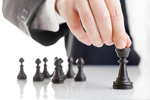 Hand moves a chess queen. SIEM Strategy
